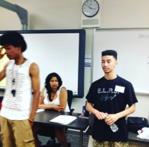 A group of people standing in front of a whiteboard.