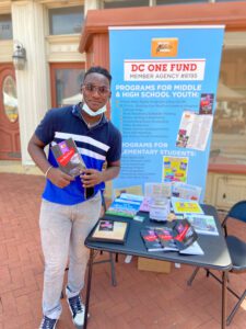 A man standing next to a table with books.